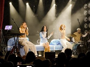 Ganges, Natalia y Mira Paula, cantando sobre el sofá azul de Natalia en el escenario Sala Oasis de Zaragoza